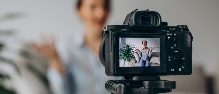 Young woman blogger recording video on camera